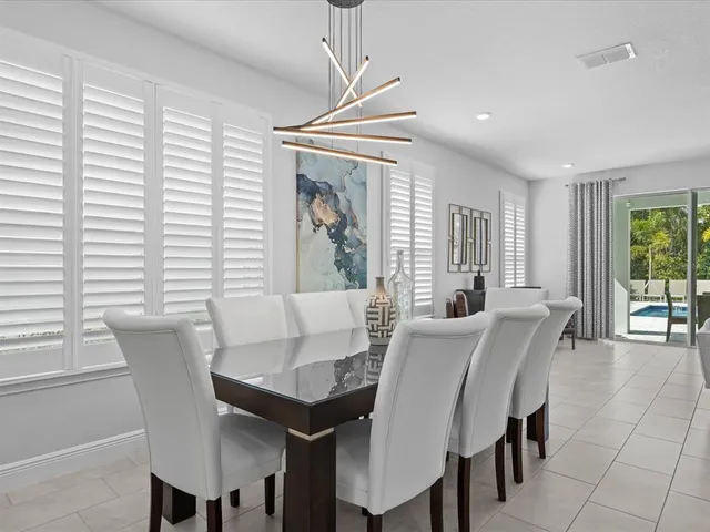 a spacious bedroom with a bed a table and painting on the wall