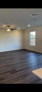 a view of an empty room with wooden floor