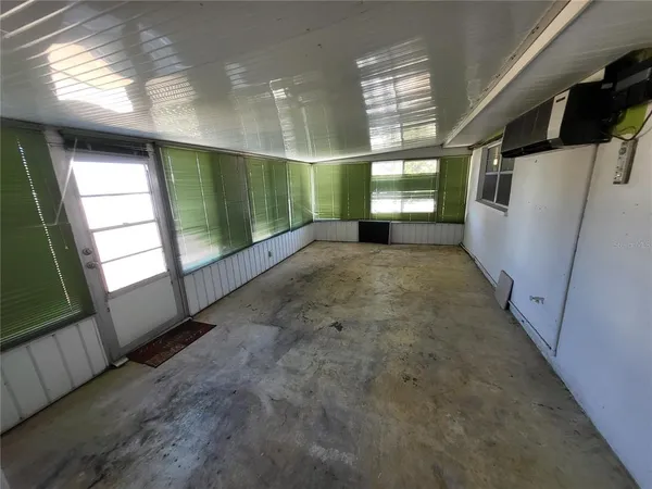 a view of a big room with wooden floor and windows