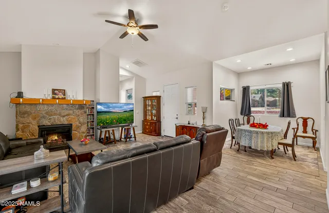 a kitchen with stainless steel appliances granite countertop a refrigerator a sink dishwasher a stove and white countertops with wooden floor