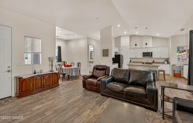 a kitchen with stainless steel appliances granite countertop a stove top oven a sink a refrigerator and white cabinets