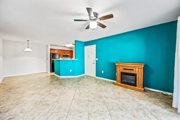 a view of a livingroom with a fireplace and a ceiling fan