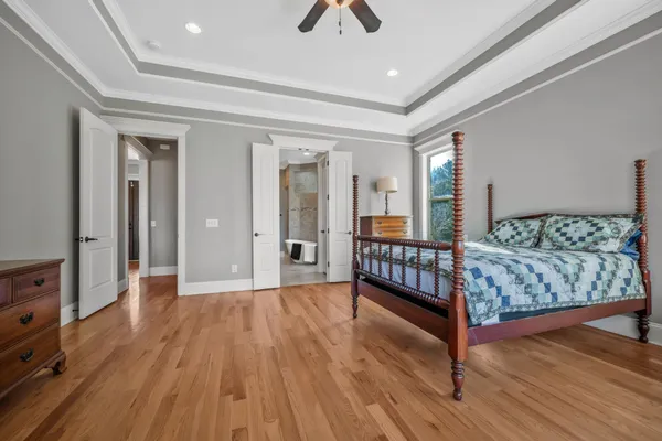 wooden floor that has a bed and a window