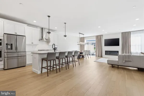 a kitchen with stainless steel appliances kitchen island granite countertop a table chairs and a refrigerator