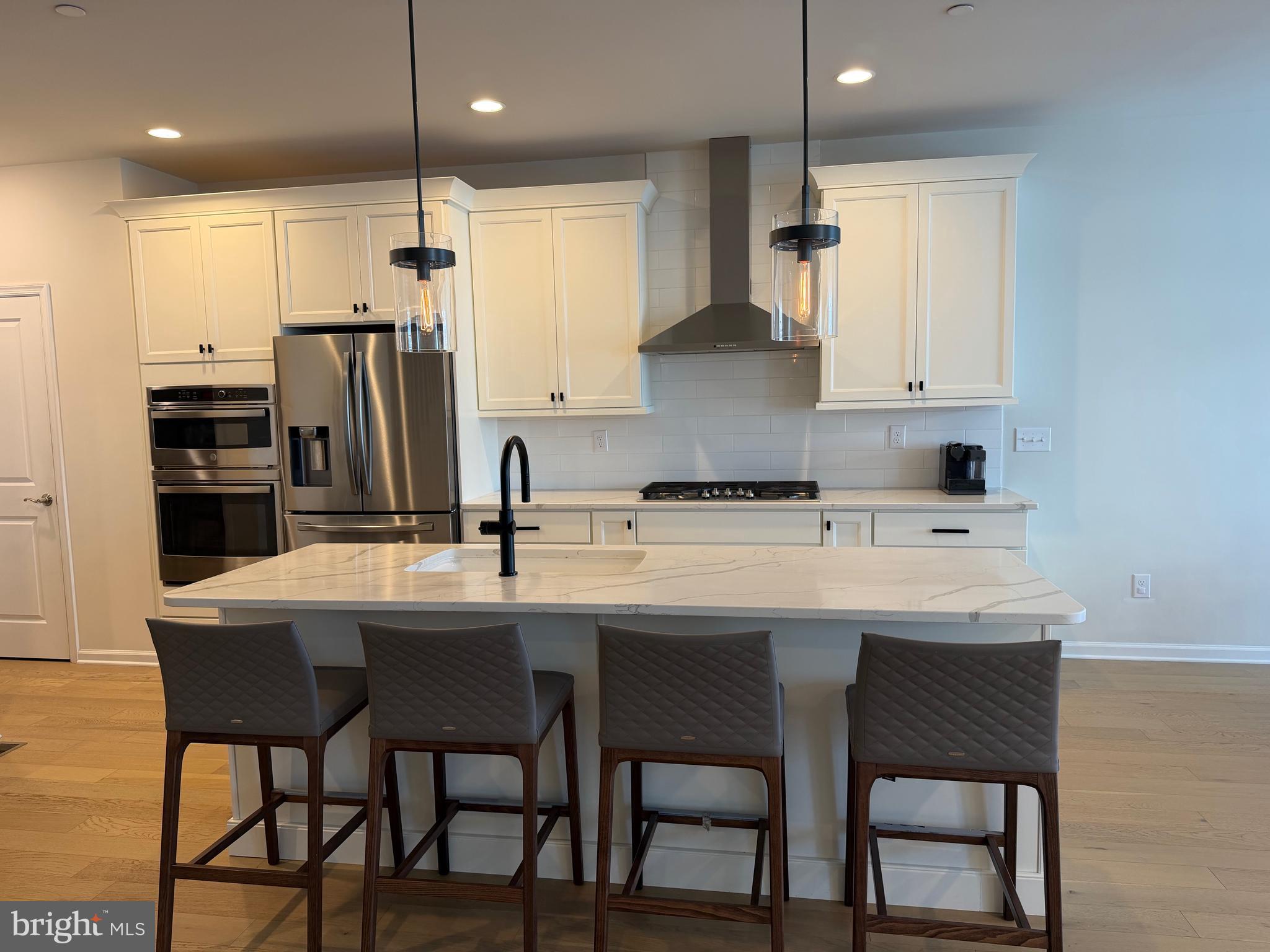 12 Spring Mill Drive Ivyland, PA 18974 - Photo 6 of 25 a kitchen with stainless steel appliances kitchen island granite countertop a table chairs microwave and sink