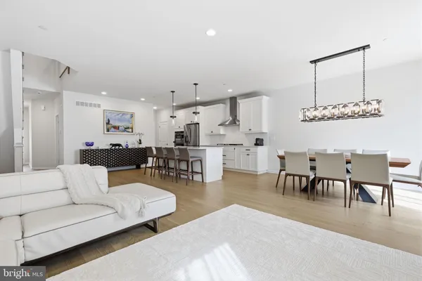 a kitchen with stainless steel appliances a refrigerator a stove and white cabinets