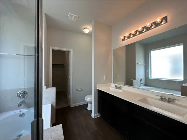 a bathroom with a double vanity sink a mirror and a bathtub