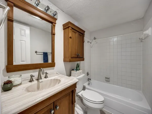 a bathroom with a granite countertop sink toilet and shower