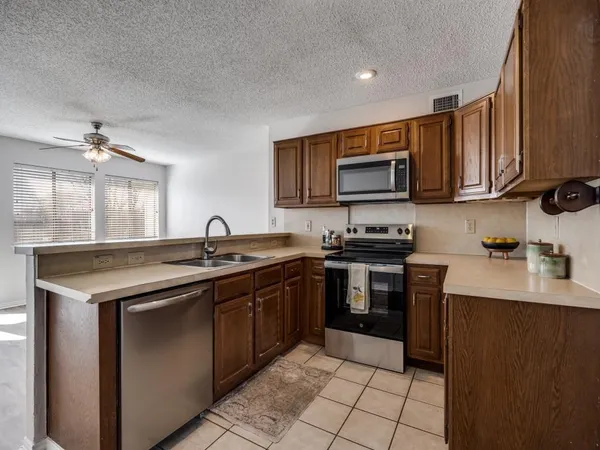 a kitchen with a sink and a stove top oven with wooden floor
