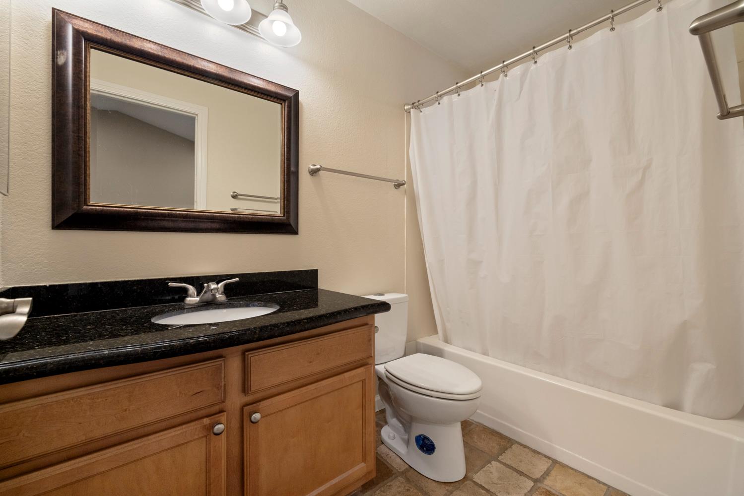 3901 Dale Road, Unit A Modesto, CA 95356 - Photo 21 of 23 a bathroom with a toilet sink and mirror