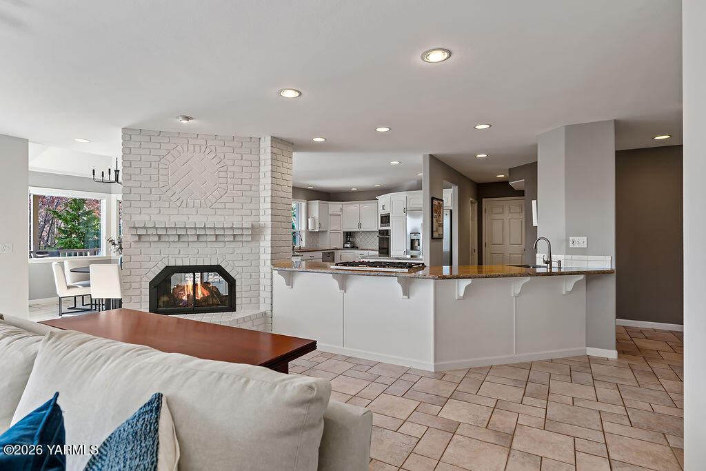 6810 Ravens Gate Way Yakima, WA 98908 - Photo 3 of 49 a living room with furniture a fireplace and kitchen view