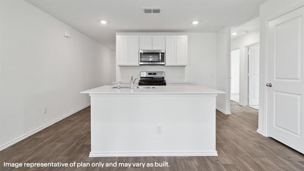 3522 Spring Time Street Forney, TX 75126 - Photo 3 of 27 Contemporary kitchen featuring an island with a sink, white cabinetry, stainless steel appliances, recessed lighting, and wood-finish flooring