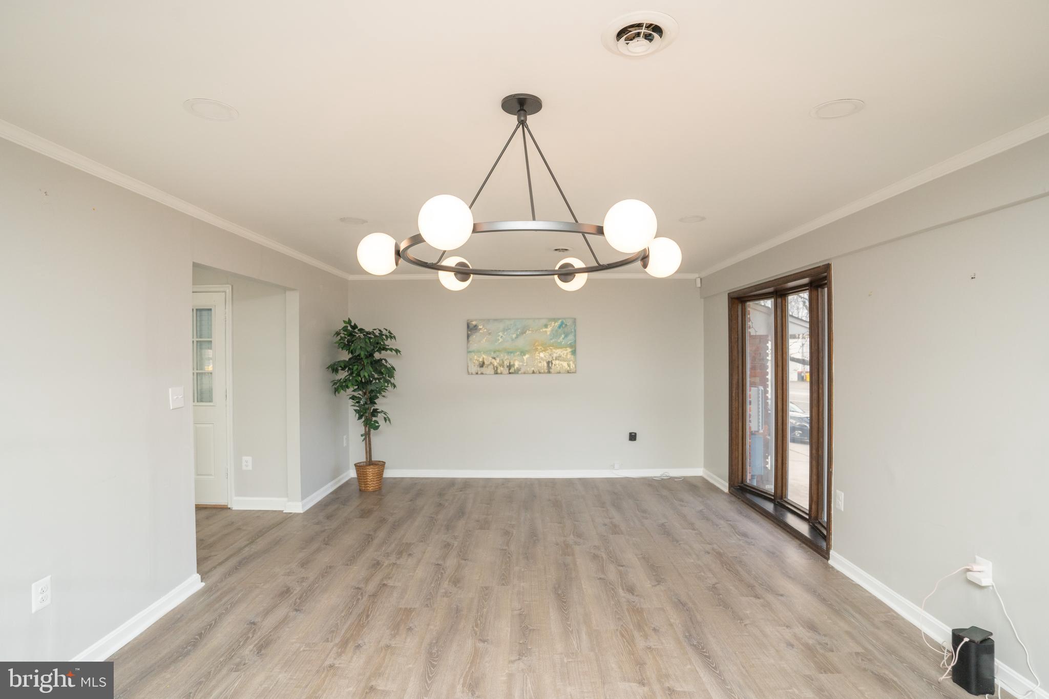 a view of a room with wooden floor and chandelier