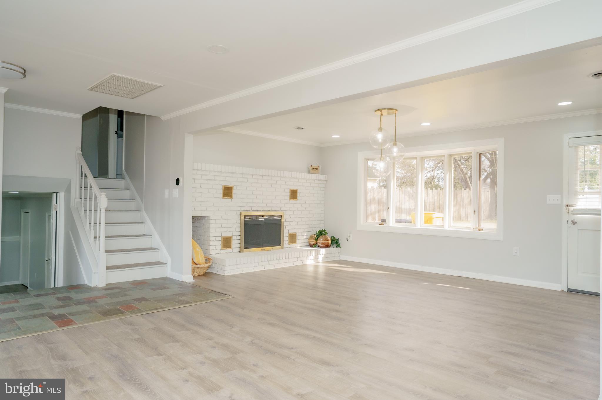 907 Reece Road Severn, MD 21144 - Photo 14 of 56 an empty room with wooden floor and windows