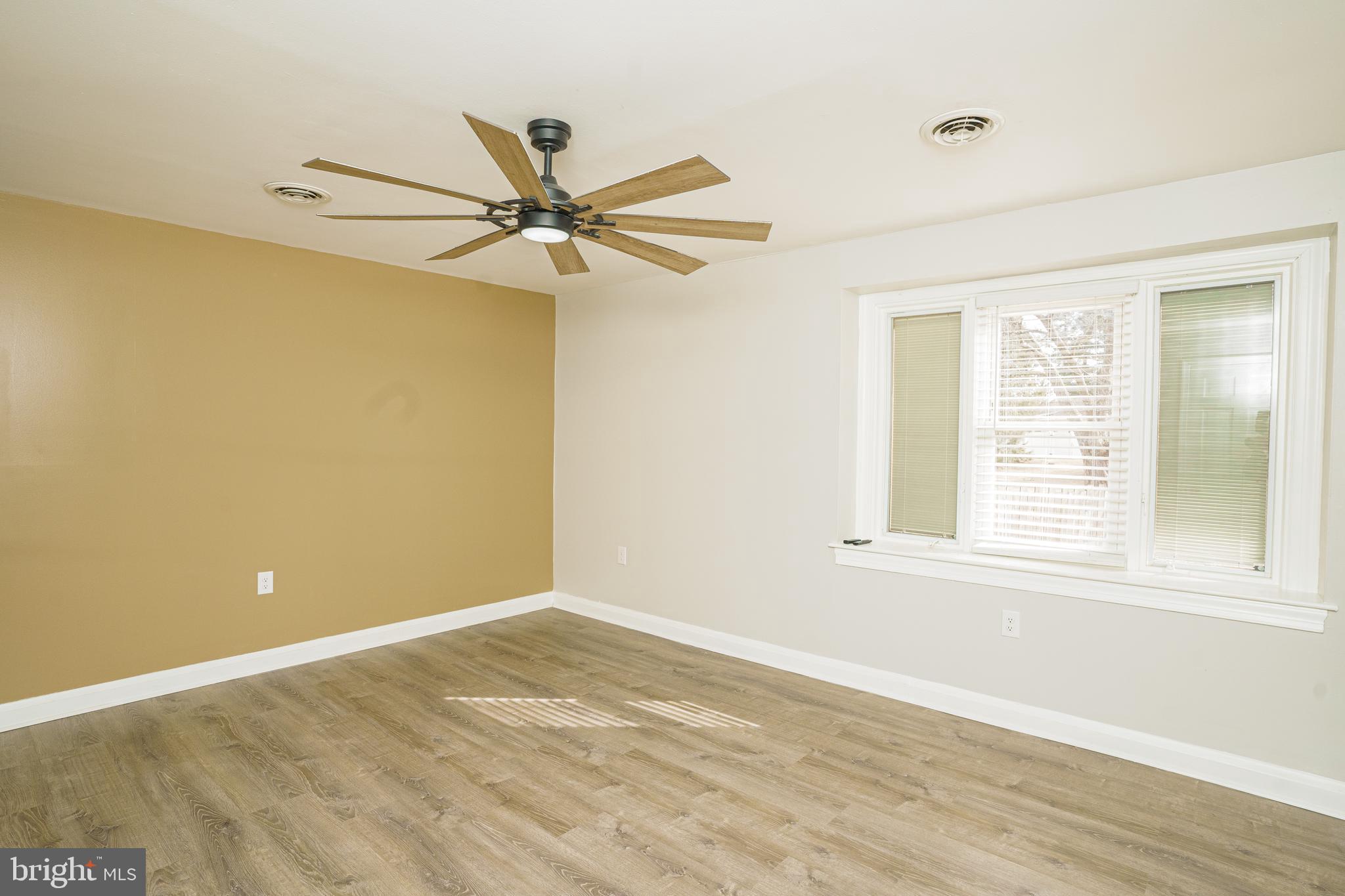 907 Reece Road Severn, MD 21144 - Photo 21 of 56 a view of a big room with wooden floor a ceiling fan and windows