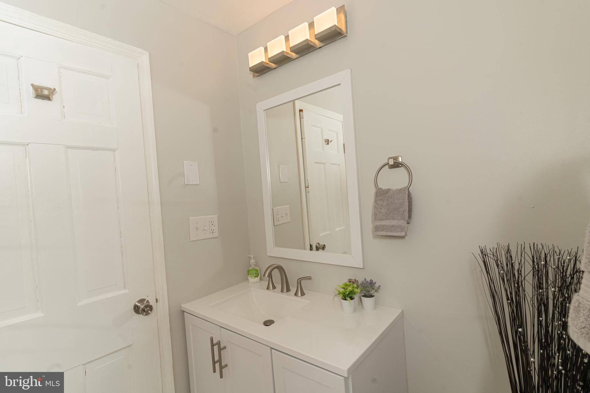 907 Reece Road Severn, MD 21144 - Photo 31 of 56 a bathroom with a sink a mirror and vanity