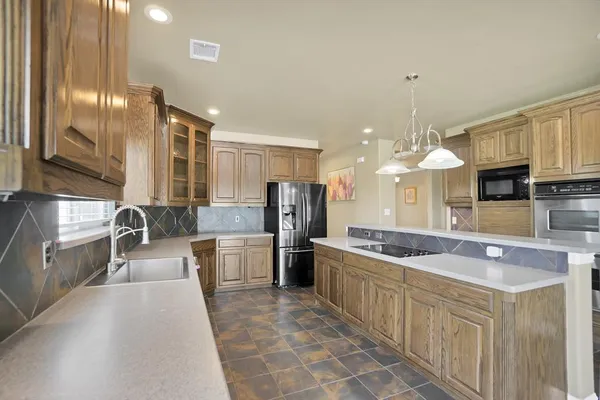 a kitchen with stainless steel appliances granite countertop a sink and a refrigerator