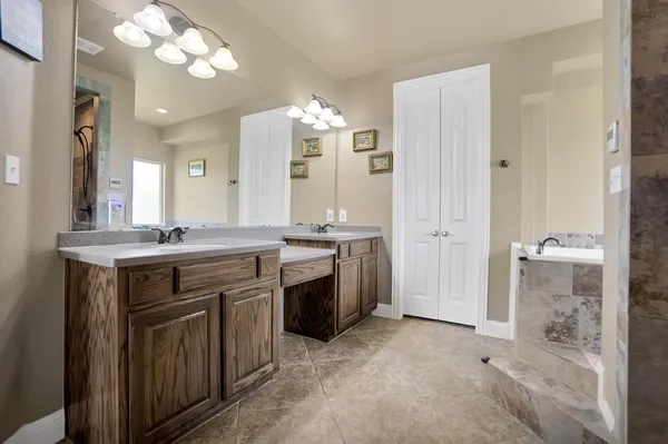 a spacious bathroom with a granite countertop sink a mirror and a shower