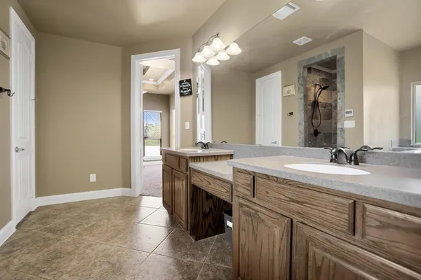 a bathroom with a granite countertop sink a large mirror and a shower