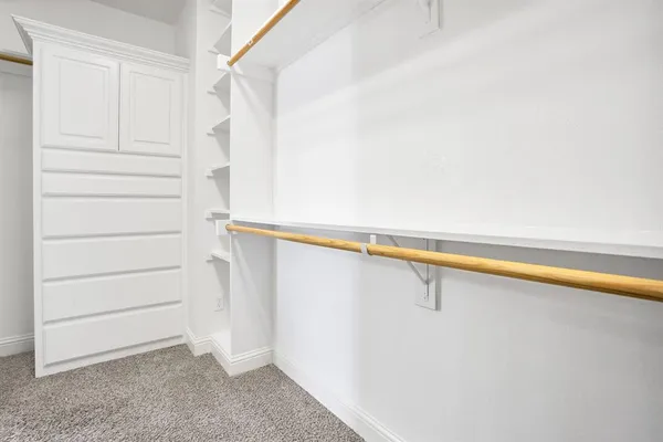 a view of walk in closet with empty racks