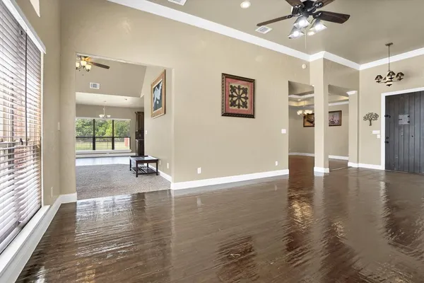 a view of a livingroom with wooden floor and a ceiling fan