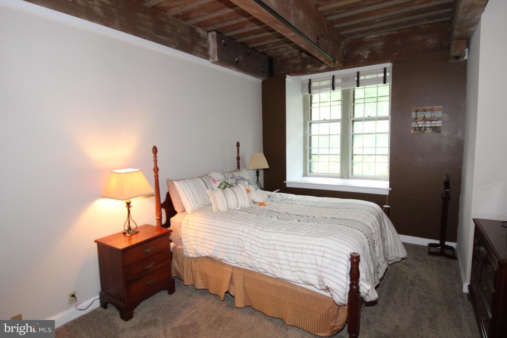 49 Bancroft Mills Road, Unit 3J Wilmington, DE 19806 - Photo 11 of 25 a bedroom with a bed window and lamp