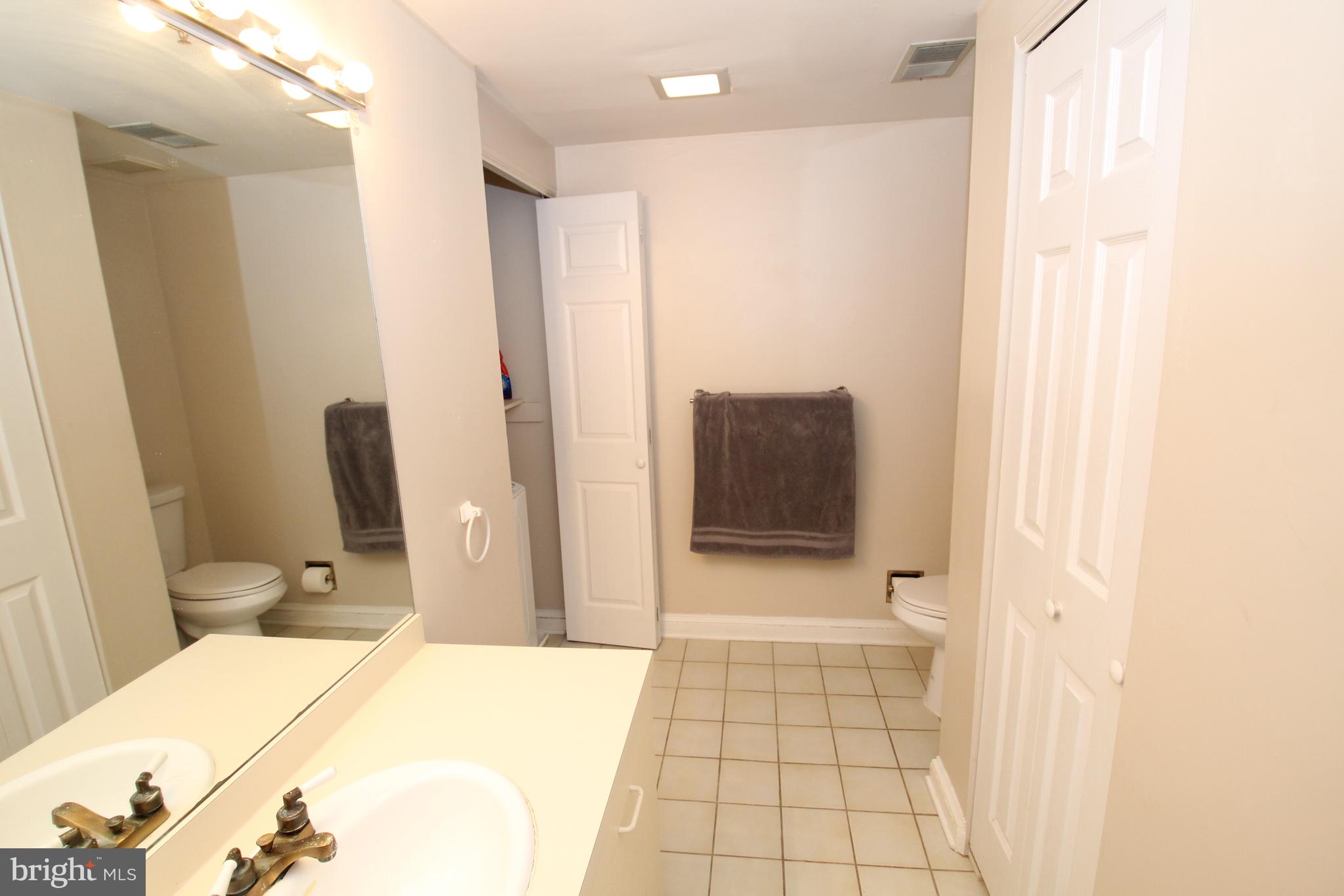 49 Bancroft Mills Road, Unit 3J Wilmington, DE 19806 - Photo 18 of 25 a bathroom with a sink and a mirror