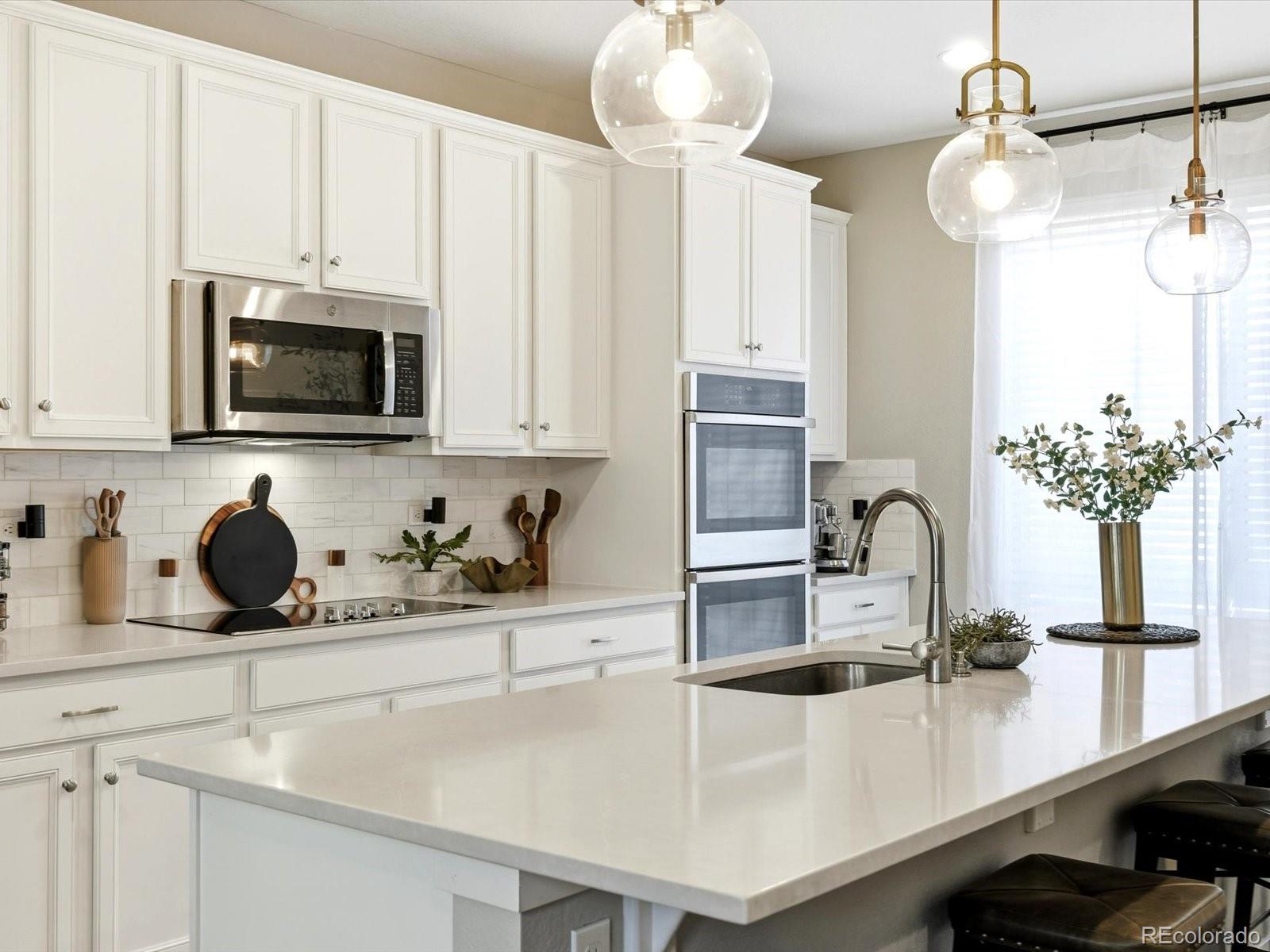 8338 Rivulet Point Highlands Ranch, CO 80129 - Photo 12 of 50 a kitchen with a sink a microwave and cabinets