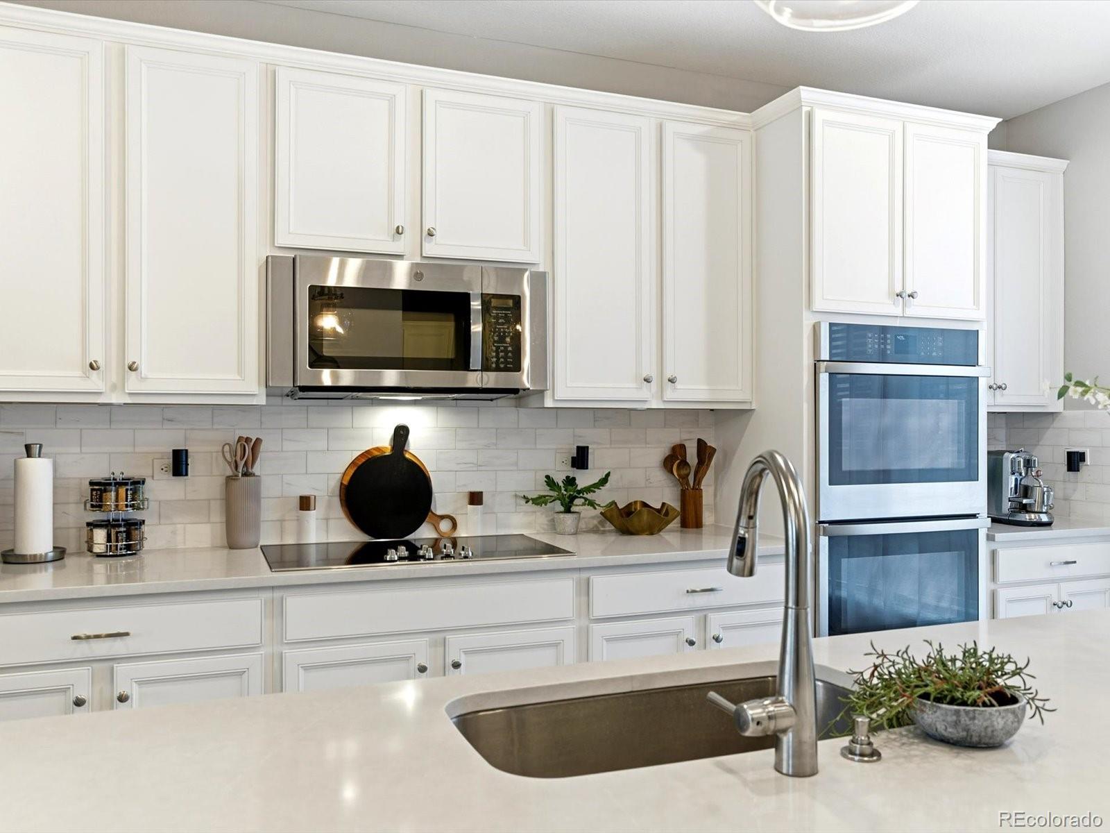 8338 Rivulet Point Highlands Ranch, CO 80129 - Photo 15 of 50 a kitchen with a sink a microwave and cabinets