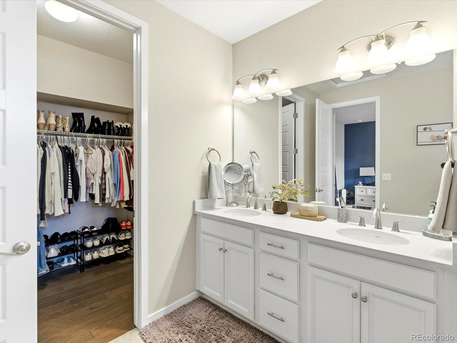 8338 Rivulet Point Highlands Ranch, CO 80129 - Photo 34 of 50 a en suite bathroom with a double vanity sink and a mirror