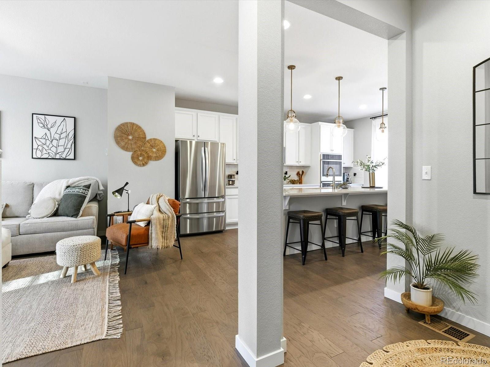 8338 Rivulet Point Highlands Ranch, CO 80129 - Photo 9 of 50 a living room with furniture kitchen view and a chandelier