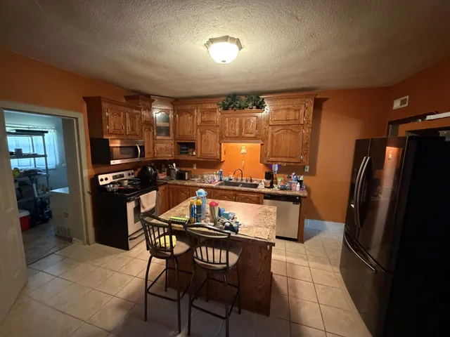 a kitchen with sink refrigerator and stove top oven