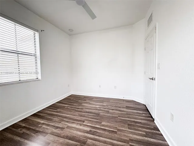 a view of a room with wooden floor and window