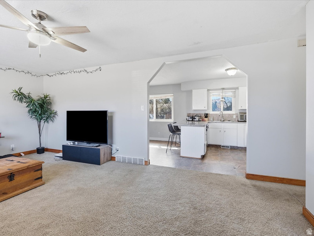 322 East 900 North Logan, UT 84321 - Photo 7 of 43 Living room featuring light colored carpet, ceiling fan, and arched walkways