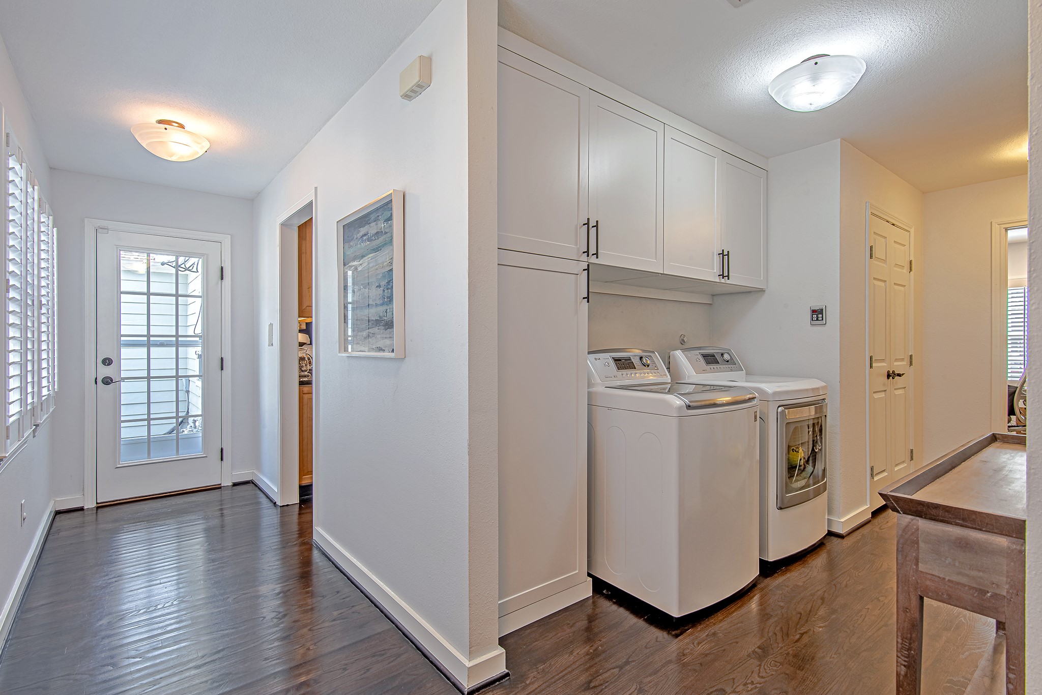 520 West 30th Street Houston, TX 77018 - Photo 13 of 28 This well-lit hallway behind the kitchen offers easy access to the backyard through a glass door. The laundry area is conveniently located on the right, with additional space for a study or storage, adding to the home's practicality.