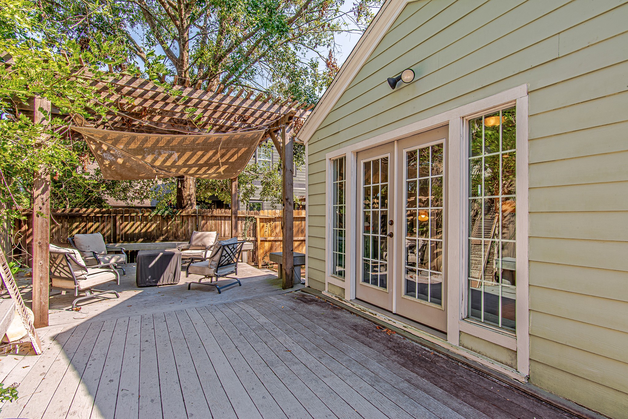 520 West 30th Street Houston, TX 77018 - Photo 25 of 28 This inviting outdoor deck is accessible through double French doors from the flex space off the living room. The pergola provides a shaded area, perfect for outdoor seating and entertaining, enhancing the home's appeal for indoor-outdoor living.