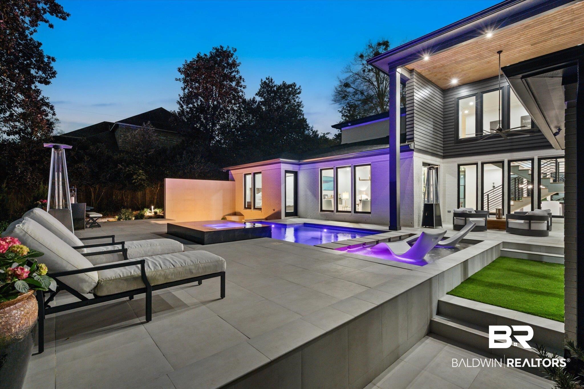 69 Jordan Lane Mobile, AL 36608 - Photo 46 of 57 Back of house at dusk featuring a patio area, outdoor furniture, and a pool with connected hot tub
