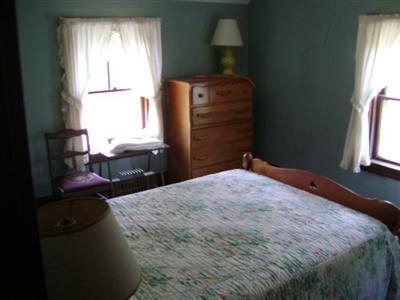 68 Nickerson Road Cotuit, MA 02635 - Photo 9 of 12 a bedroom with a bed dresser and a window