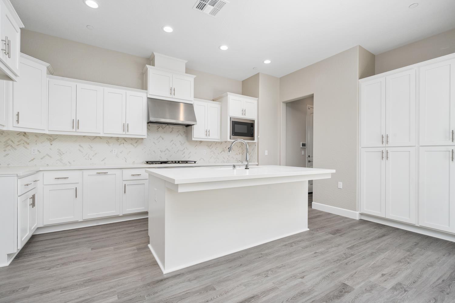 272 Peters Road Madera, CA 93636 - Photo 8 of 25 a kitchen with kitchen island white cabinets and white appliances