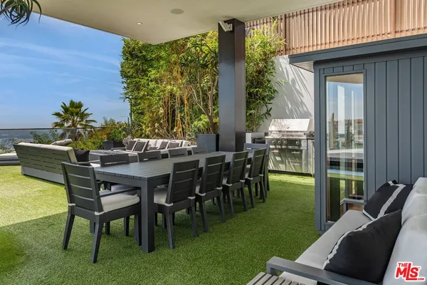 a view of a patio with couches table and chairs with garden view