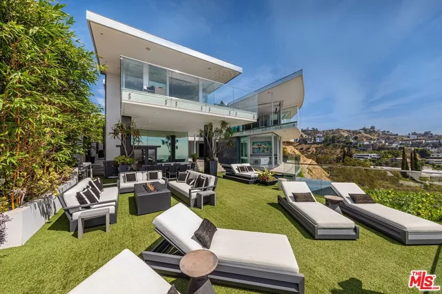 a view of a house with swimming pool and sitting area