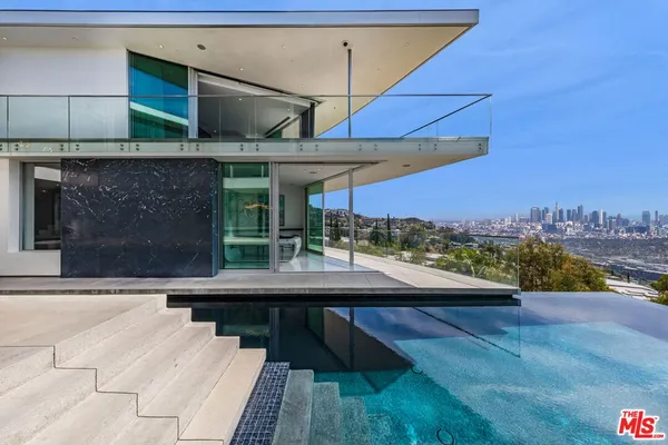 a view of a house with swimming pool and sitting area