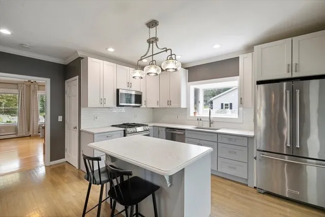 a kitchen with kitchen island a refrigerator a stove a dining table and chairs