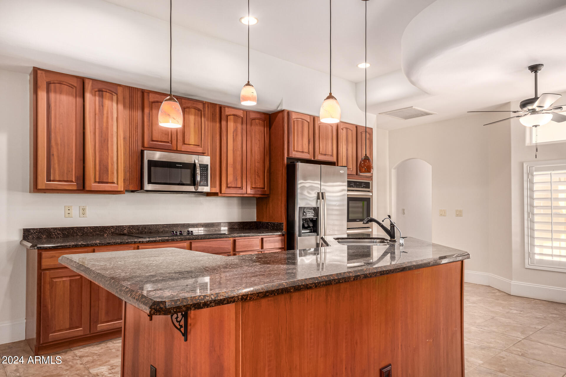 10589 West Harmon Road Eloy, AZ 85131 - Photo 23 of 82 a kitchen with stainless steel appliances granite countertop a sink a microwave and wooden cabinets