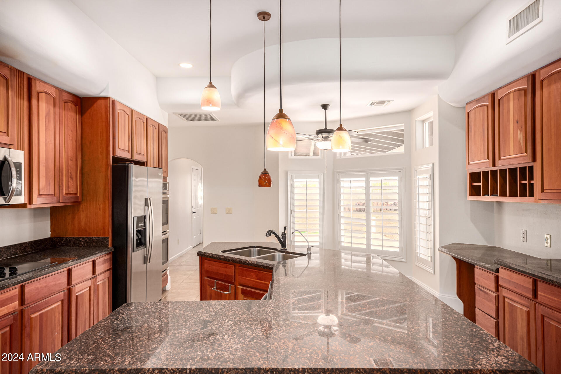 10589 West Harmon Road Eloy, AZ 85131 - Photo 27 of 82 a kitchen with stainless steel appliances granite countertop a refrigerator a sink dishwasher a stove a dining table and chairs with wooden floor