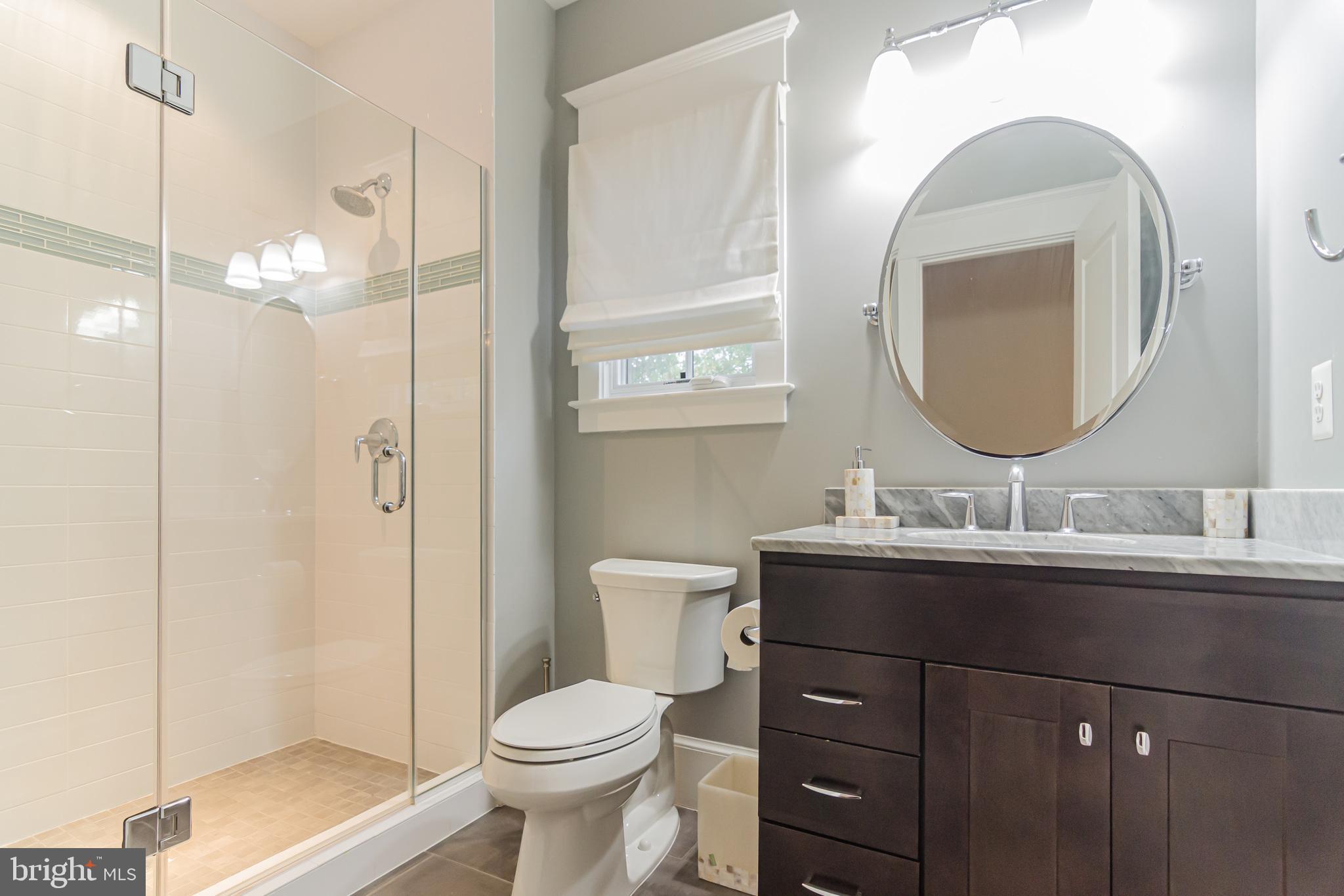 6801 Danforth Street McLean, VA 22101 - Photo 26 of 29 a bathroom with a toilet a sink a mirror a vanity and shower