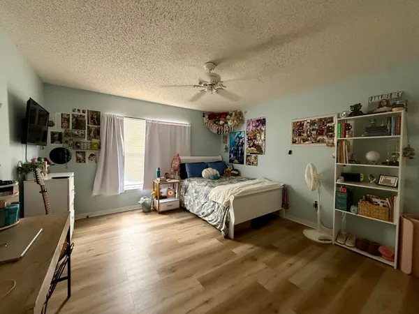 a bedroom with a bed and a flat tv screen on the dresser