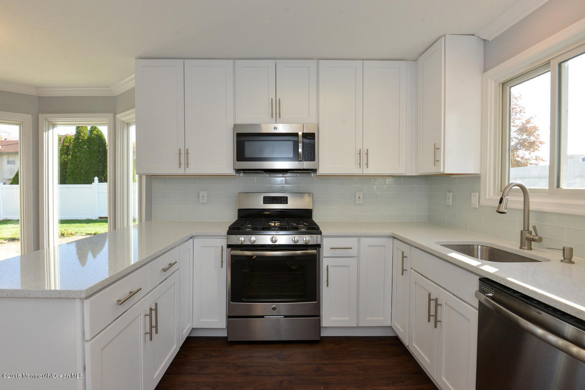 93 Friendship Road Howell, NJ 07731 - Photo 13 of 51 a kitchen with stainless steel appliances white cabinets and a stove top oven