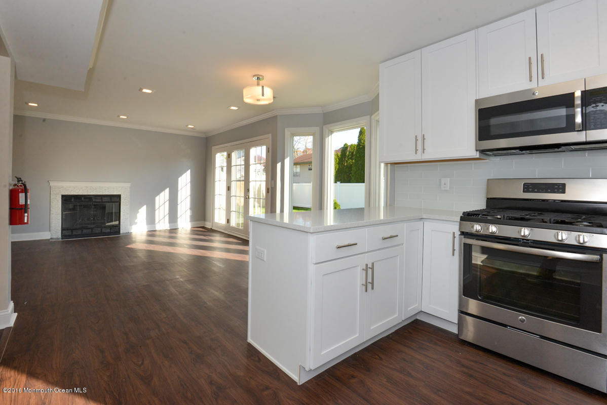 93 Friendship Road Howell, NJ 07731 - Photo 14 of 51 a kitchen with stainless steel appliances granite countertop a stove a sink and a microwave