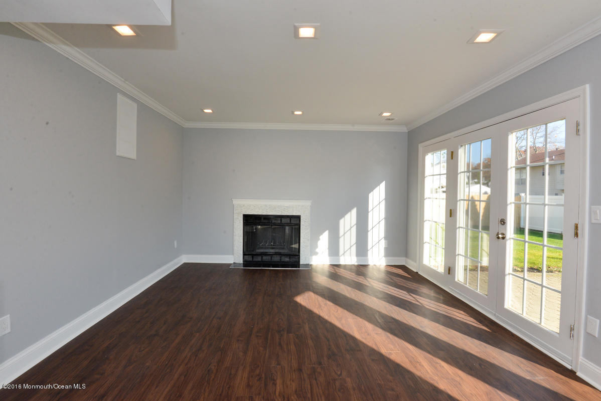 93 Friendship Road Howell, NJ 07731 - Photo 18 of 51 a view of empty room with wooden floor and fireplace